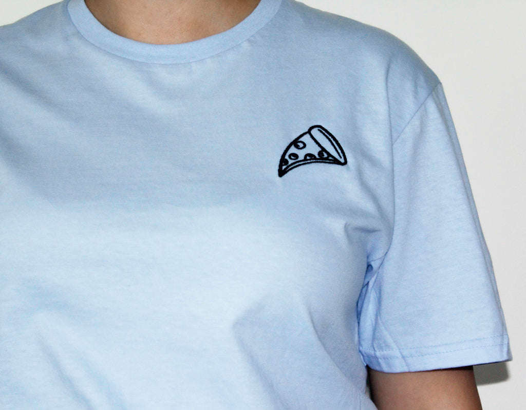 Light blue t-shirt with a black pizza slice embroidery on a plain background