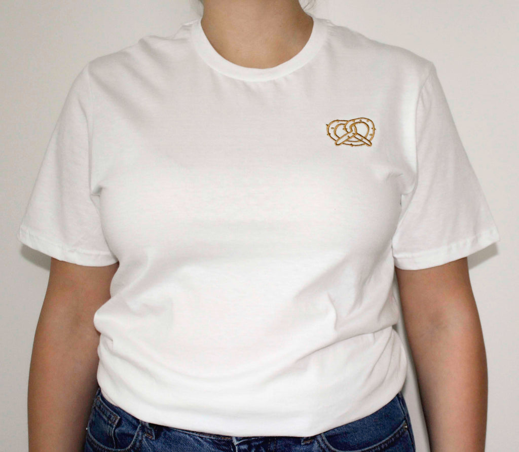 White t-shirt with a pretzel embroidery on a plain background